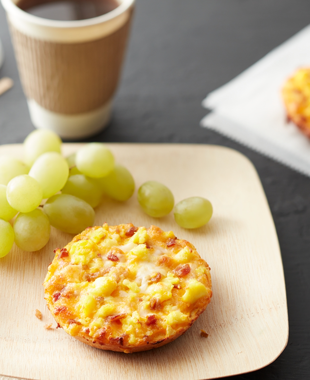 personal-sized breakfast pizza on a plate with a cup of coffee