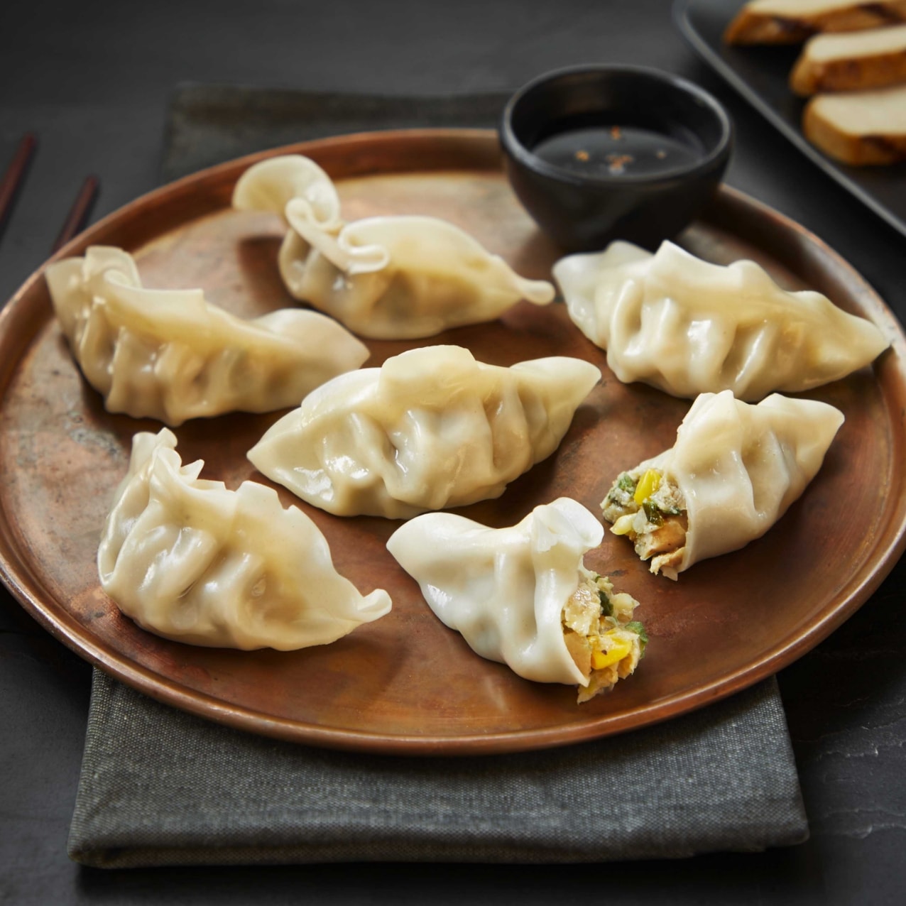 several dumplings on a serving tray with soy sauce