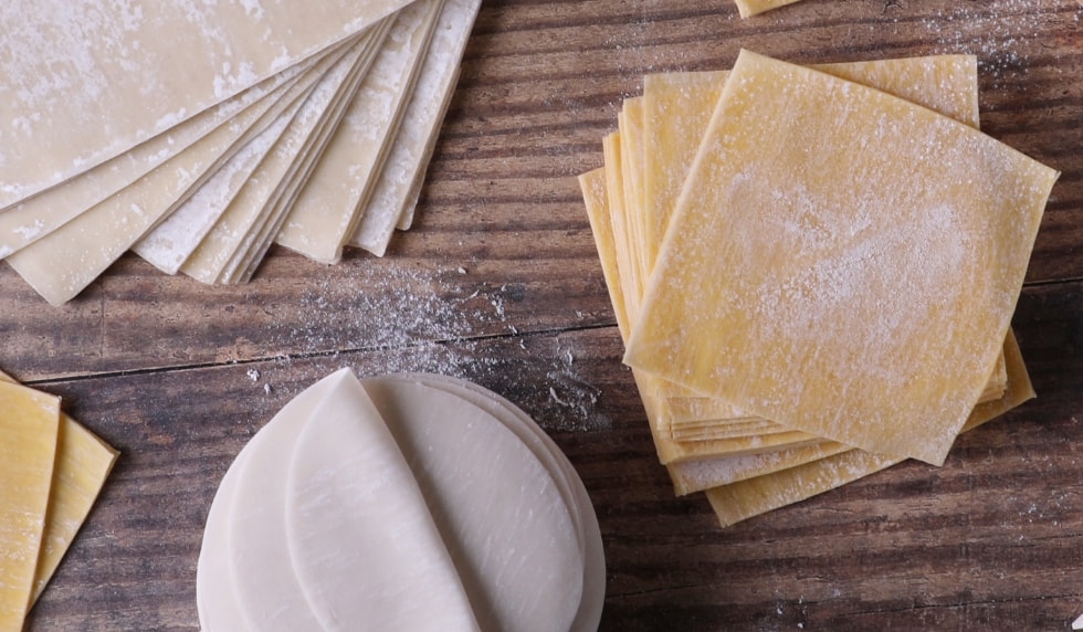 Various wrappers for Asian foods on a cutting board