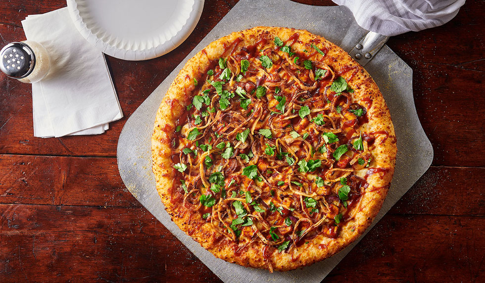 overhead photo of half of a pizza with eggs, bacon and mushrooms