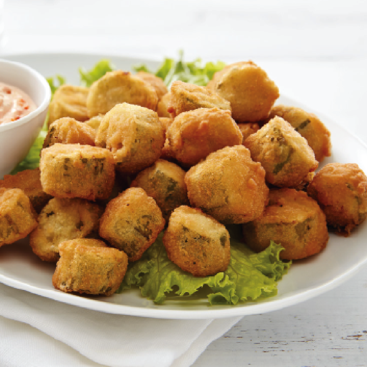 breaded, fried okra in a bowl on a lettuce leaf