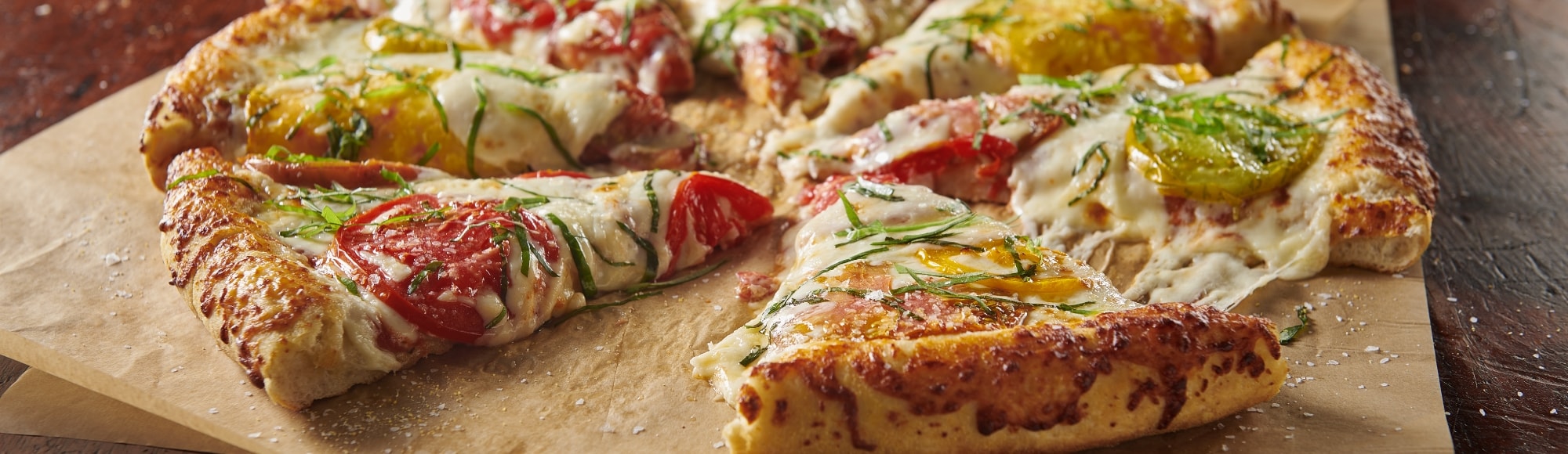 close up of sliced pepperoni pizza on serving paper