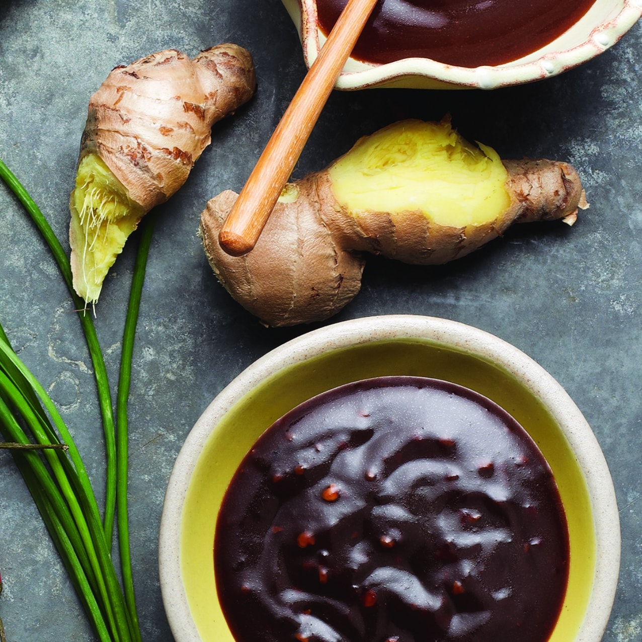 overhead photo of sauces in a bowl next to a ginger root