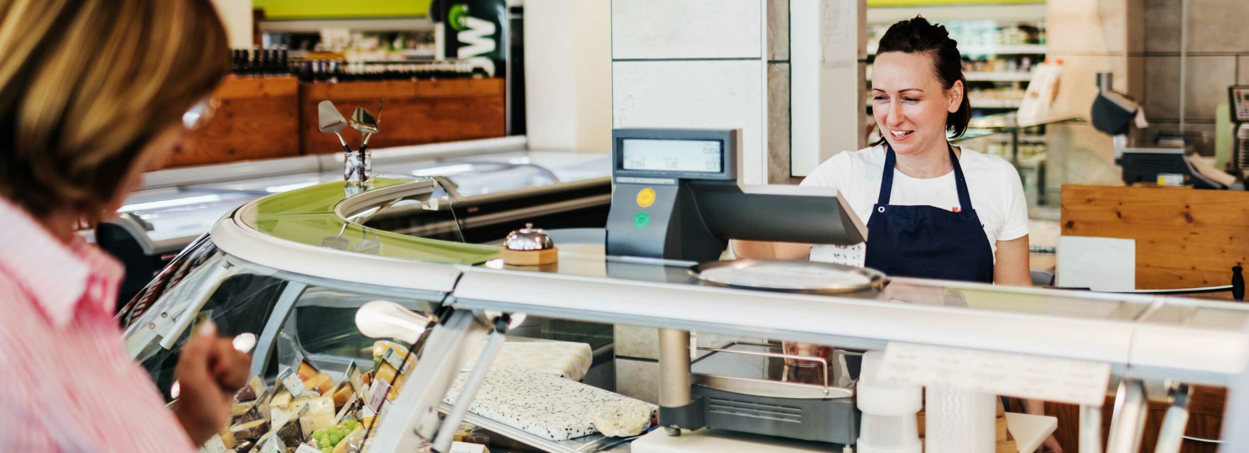 a customer and deli clerk at a cash register